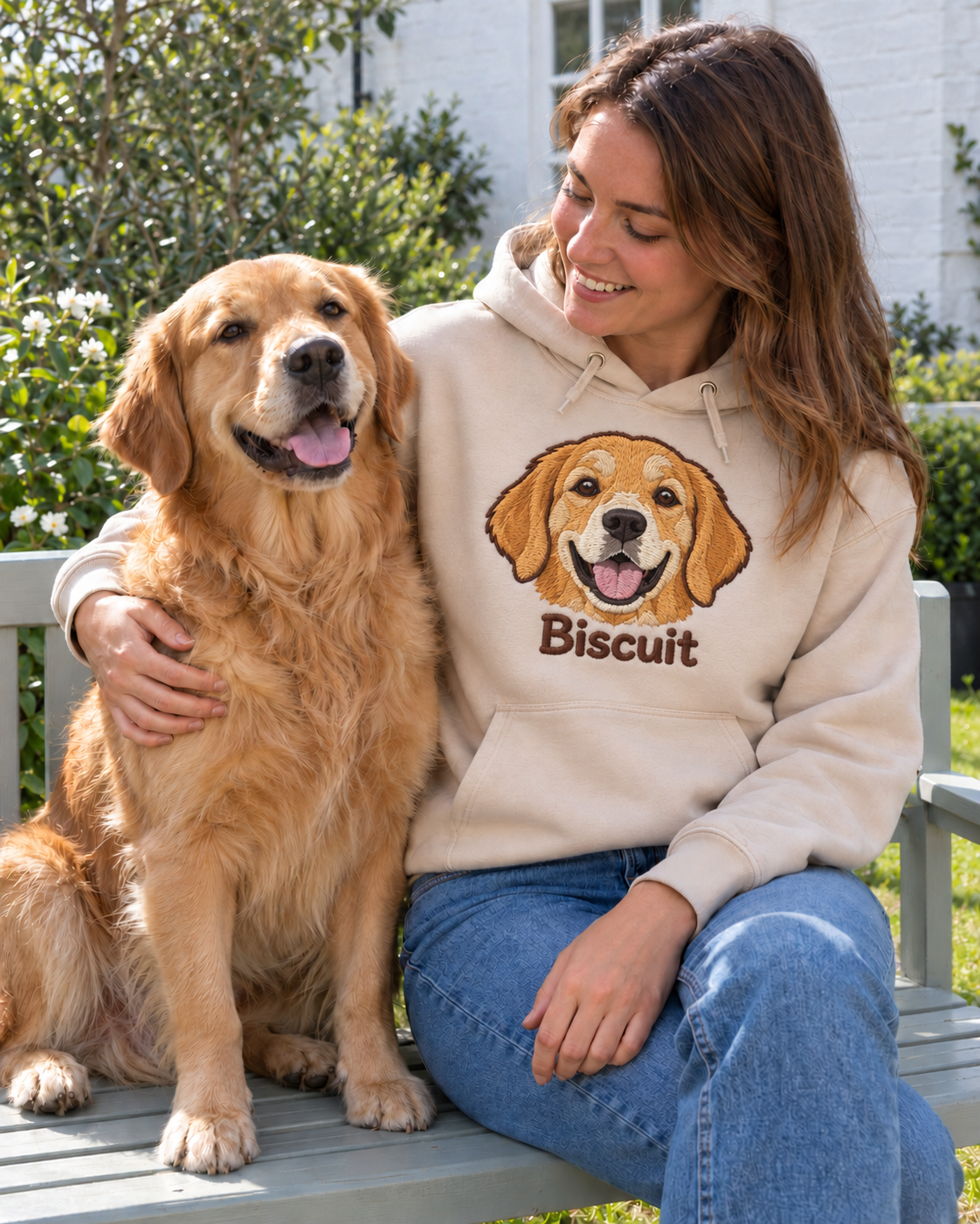 Woman on a garden bench with her golden retriever Biscuit, wearing a Desert Dust hoodie embroidered with Biscuit
